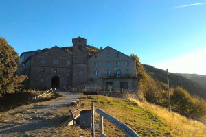 Veduta del Santuario e del complesso storico di San Pellegrino in Alpe al tramonto, lungo il Cammino di Santa Giulia.