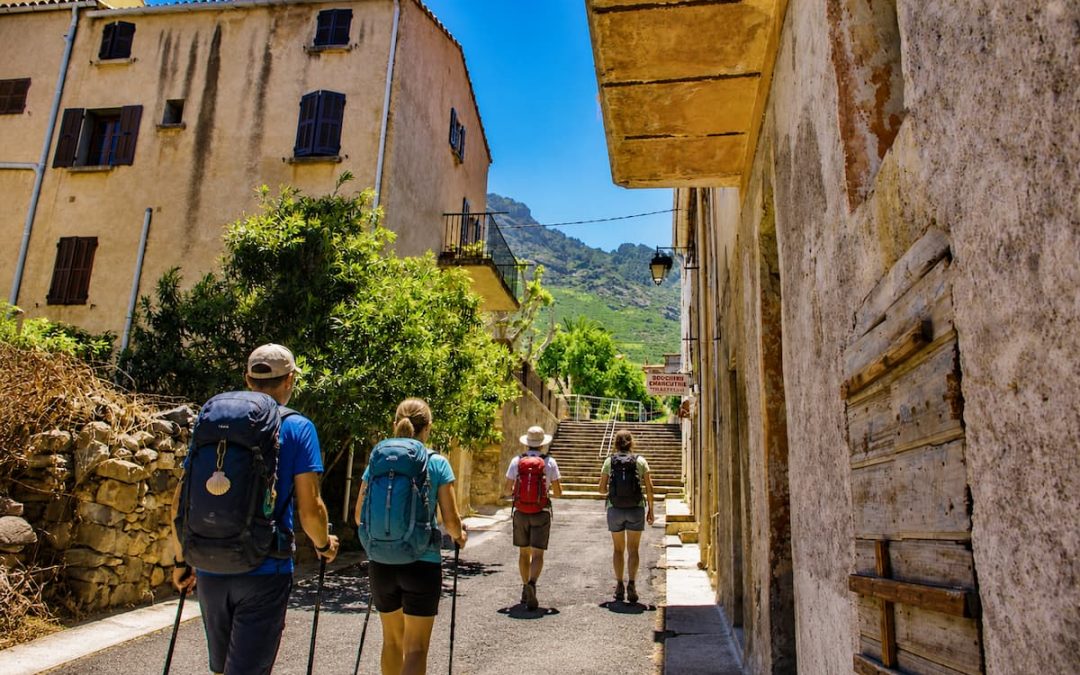 Pellegrini con zaino arrivano nel borgo di Calenzana in Corsica lungo il Cammino di Santa Giulia, porta del GR20